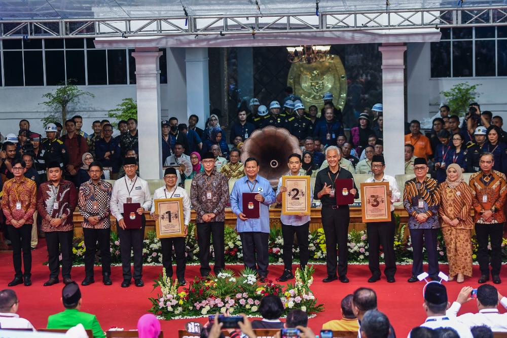 Ketua Komisi Pemilihan Umum (KPU) Hasyim Asyari (tengah) bersama anggota KPU dan Capres-Cawapres peserta Pemilu 2024 berfoto bersama saat Rapat Pleno Terbuka Pengundian dan Penetapan Nomor Urut Pasangan Capres dan Cawapres Pemilu Tahun 2024 di Gedung KPU, Jakarta, Selasa (14/11/2023).