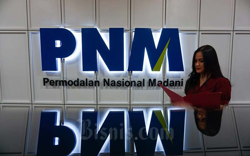 Karyawati beraktivitas di dekat logo PT Permodalan Nasional Madani (PNM) di Jakarta. Bisnis/Suselo Jati