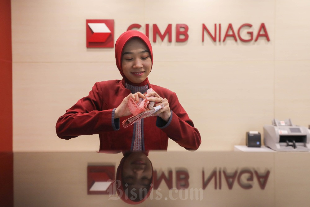 Pegawai menghitung uang rupiah di kantor cabang CIMB Niaga di Jakarta, Senin (5/2/2024). Bisnis/Himawan L Nugraha