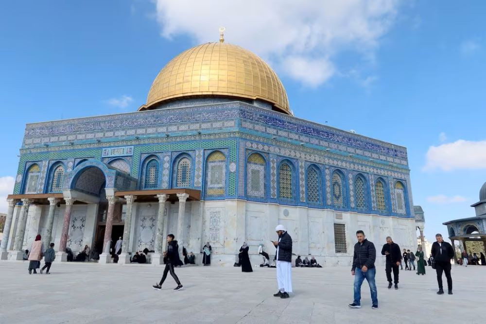 Jemaah berjalan di depan Masjid Al Aqsa di Kota Tua Yerusalem menjelang salat Jumat pada 9 Februari 2024. / Reuters