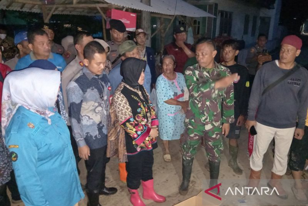 Menteri Sosial Tri Rismaharini memantau kondisi rumah warga yang rusak akibat banjir Cirebon pada Jumat (8/3/2024) malam. - ANTARA/Fathnur Rohman.