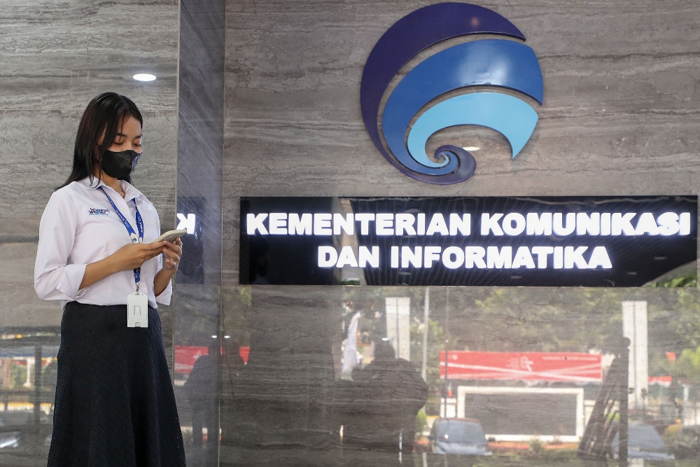 Karyawan beraktivitas di depan logo Kementerian Komunikasi dan Informatika di Jakarta, Senin (11/9/2023).JIBI/Bisnis-Eusebio Chrysnamurti