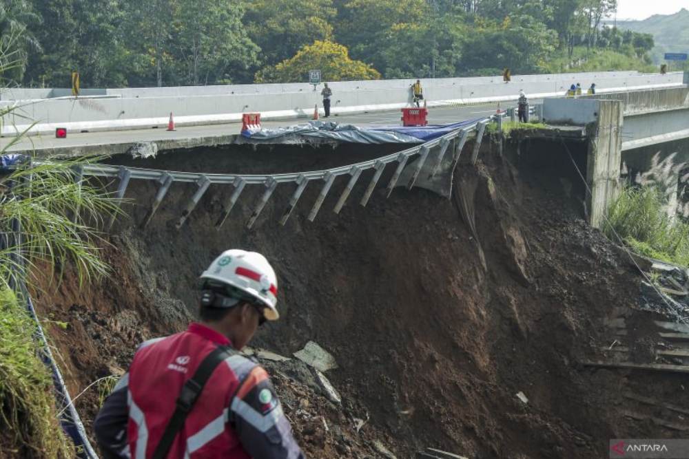 Petugas melintas di sekitar jalan tol yang amblas di ruas tol Bocimi KM 64, Sukabumi, Jawa Barat, Kamis (4/4/2024). . ANTARA FOTO/Henry Purba/agr/nym