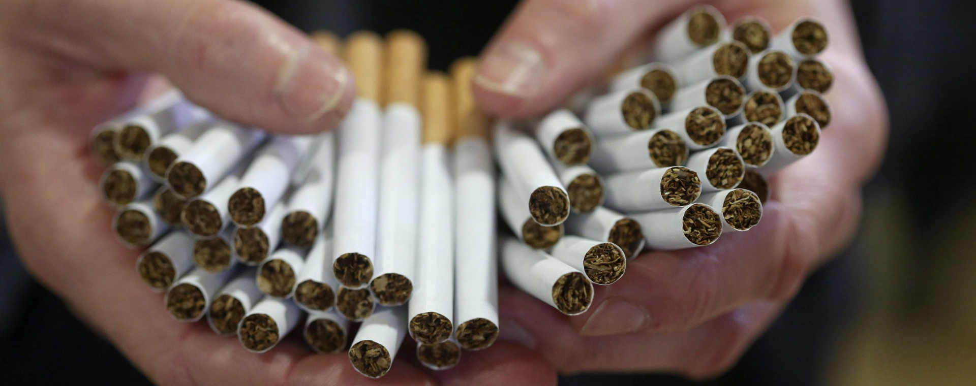Pekerja memegang rokok hasil produksi salah satu pabrik di Inggris. - Bloomberg/Chris Ratcliffe