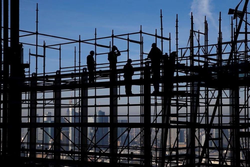 Para pekerja konstruksi terlihat siluet saat berdiri di atas platform di lokasi pembangunan kantor pusat Bank Sentral Eropa (ECB) yang baru saat tur media di Frankfurt, Jerman, 31 Oktober 2013./Reuters-Kai Pfaffenbach