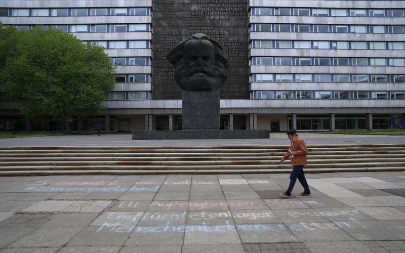 Sejarah Hari Ini 5 Mei: Karl Marx, Bapak Sosialisme dan Pendiri Komunis Lahir. Pejalan kaki melewati patung wajah Karl Marx di Chemnitz, Jerman/ Bloomberg - Krisztian Bocsi