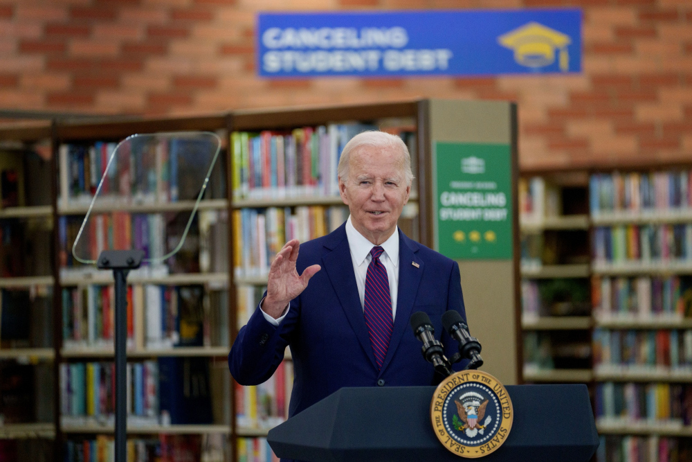 Presiden Amerika Serikat Joe Biden menyampaikan pidato di Julian Dixon Library in Culver City, California, AS pada Rabu (21/2/2024) dengan latar bertuliskan Cancelling Student Debt atau pengampunan pinjaman mahasiswa yang merupakan program pemerintah AS. - Bloomberg/Eric Thayer
