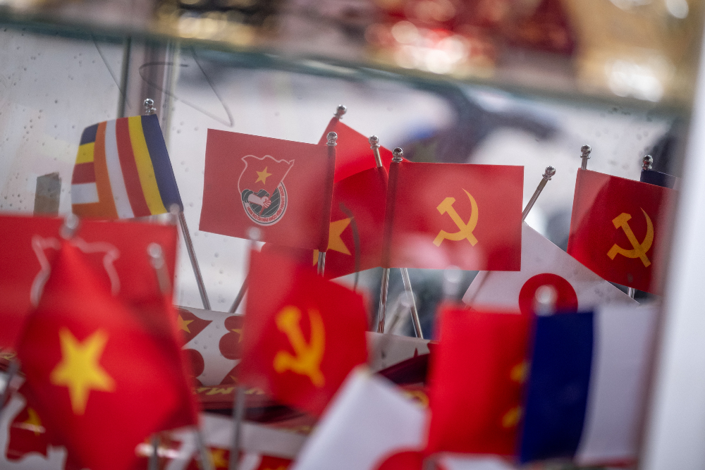 Bendera Vietnam dan bendera dengan simbol partai komunis di salah satu toko di Hanoi, Vietnam pada Selasa (14/5/2024). - Bloomberg/Linh Pham
