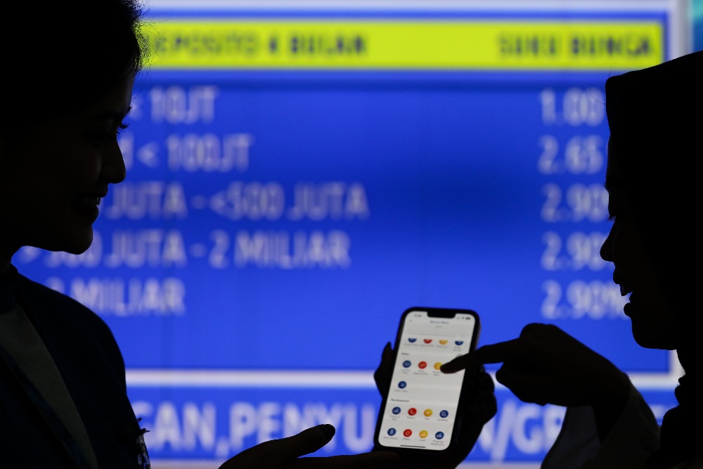 Siluet karyawati memberikan penjelasan kepada nasabah tentang aplikasi BTN Mobile di salah satu kantor cabang BTN di Jakarta, Rabu (17/1/2024). PT Bank Tabungan Negara (Persero) Tbk/JIBI/Bisnis/Arief Hermawan P