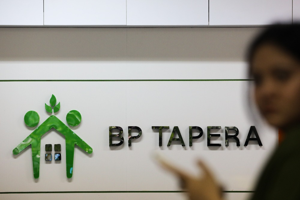 Karyawati berada di dekat logo BP Tapera di Jakarta, Rabu (5/6/2024). JIBI/Bisnis/Arief Hermawan P