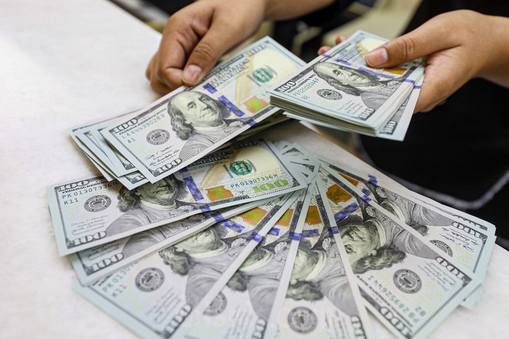 Karyawati menghitung dolar Amerika Serikat di salah satu tempat penukaran uang di Jakarta, Rabu (17/4/2024). Bisnis/Abdurachman