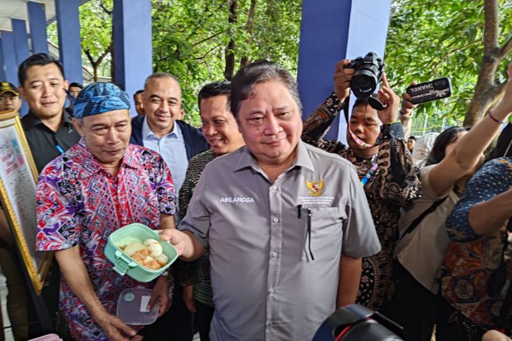 Menteri Koordinator Bidang Perekonomian Airlangga Hartato menunjukkan menu makan siang gratis untuk pelajar di SMPN 2 Curug, Kabupaten Tangerang, Banten. - ANTARA/Azmi Samsul Maarif.