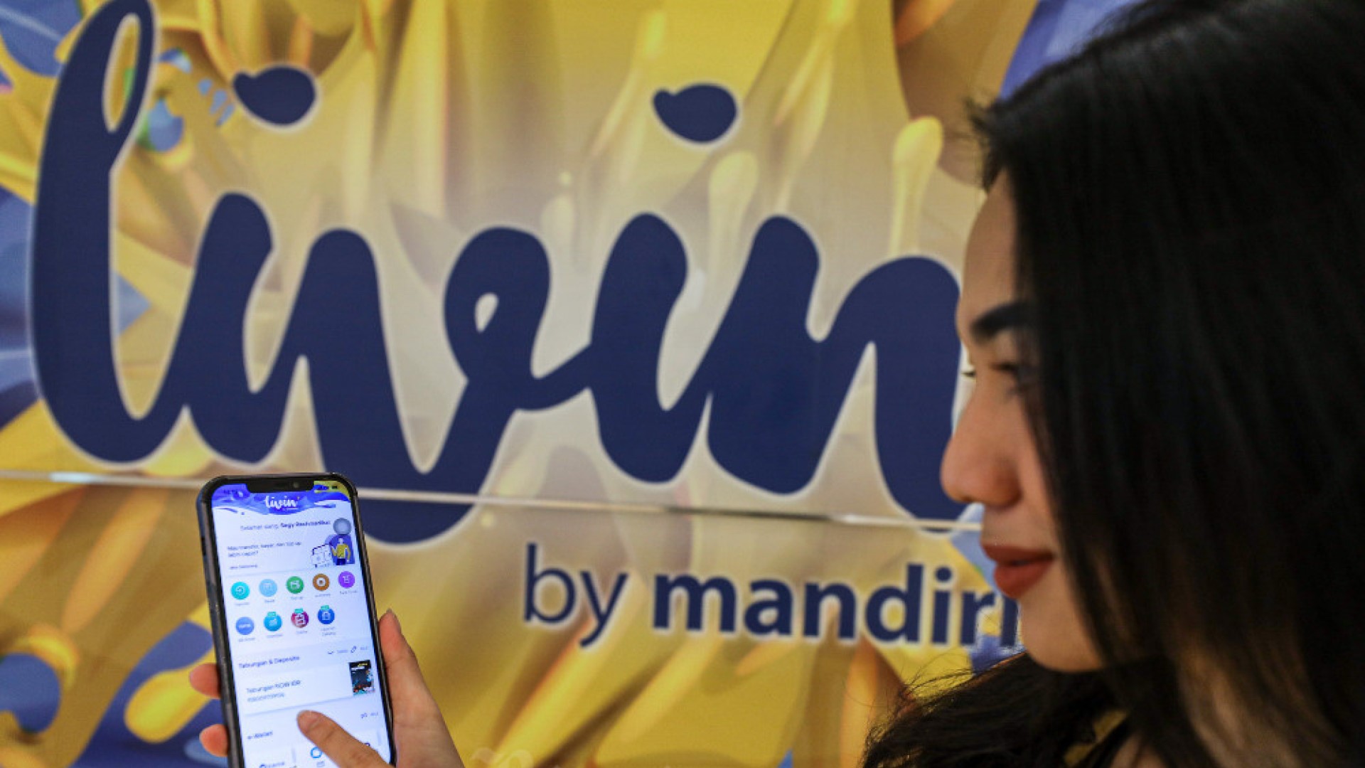 Nasabah menunjukan aplikasi Livin’ by Mandiri di salah satu kantor cabang Bank Mandiri, Jakarta, Rabu (12/10/2022). Bisnis/Abdurachman