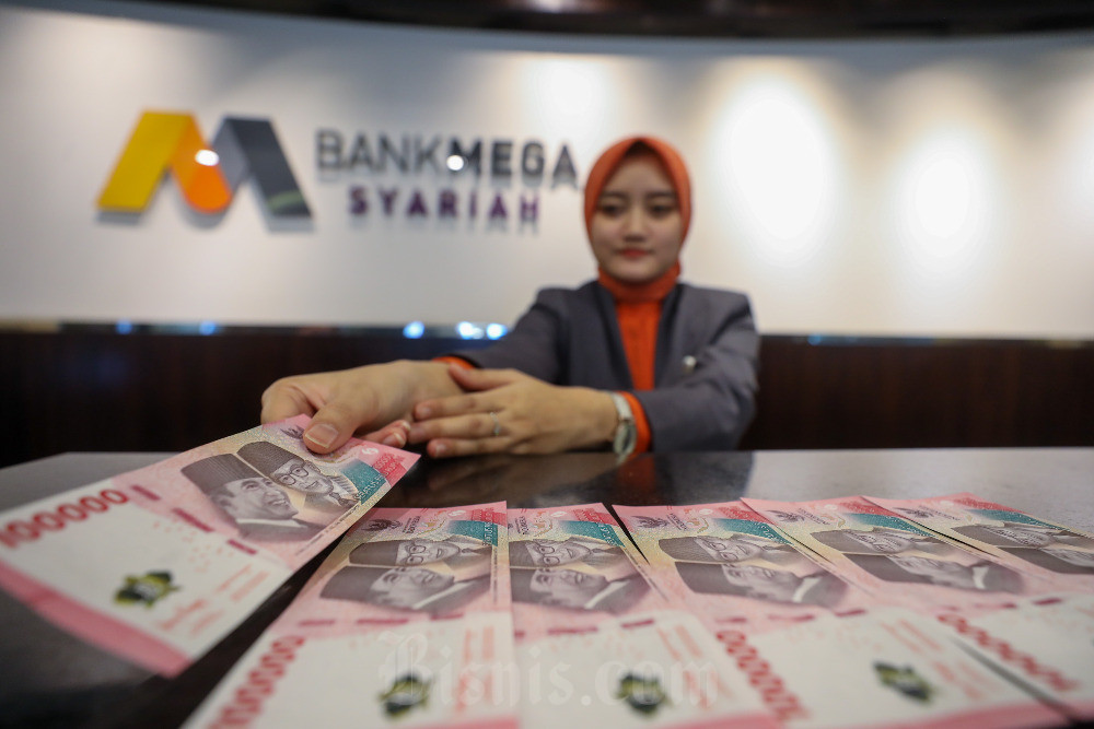 Karyawati menghitung uang di kantor cabang Bank Mega Syariah di Jakarta. / Bisnis-Abdurachman