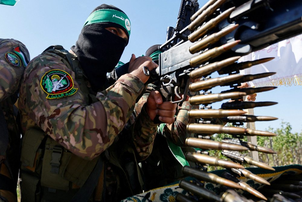Seorang pejuang Palestina dari sayap bersenjata Hamas mengambil bagian dalam parade militer untuk menandai peringatan perang tahun 2014 dengan Israel, dekat perbatasan di Jalur Gaza tengah, 19 Juli 2023. REUTERS/Ibraheem Abu Mustafa/File Foto