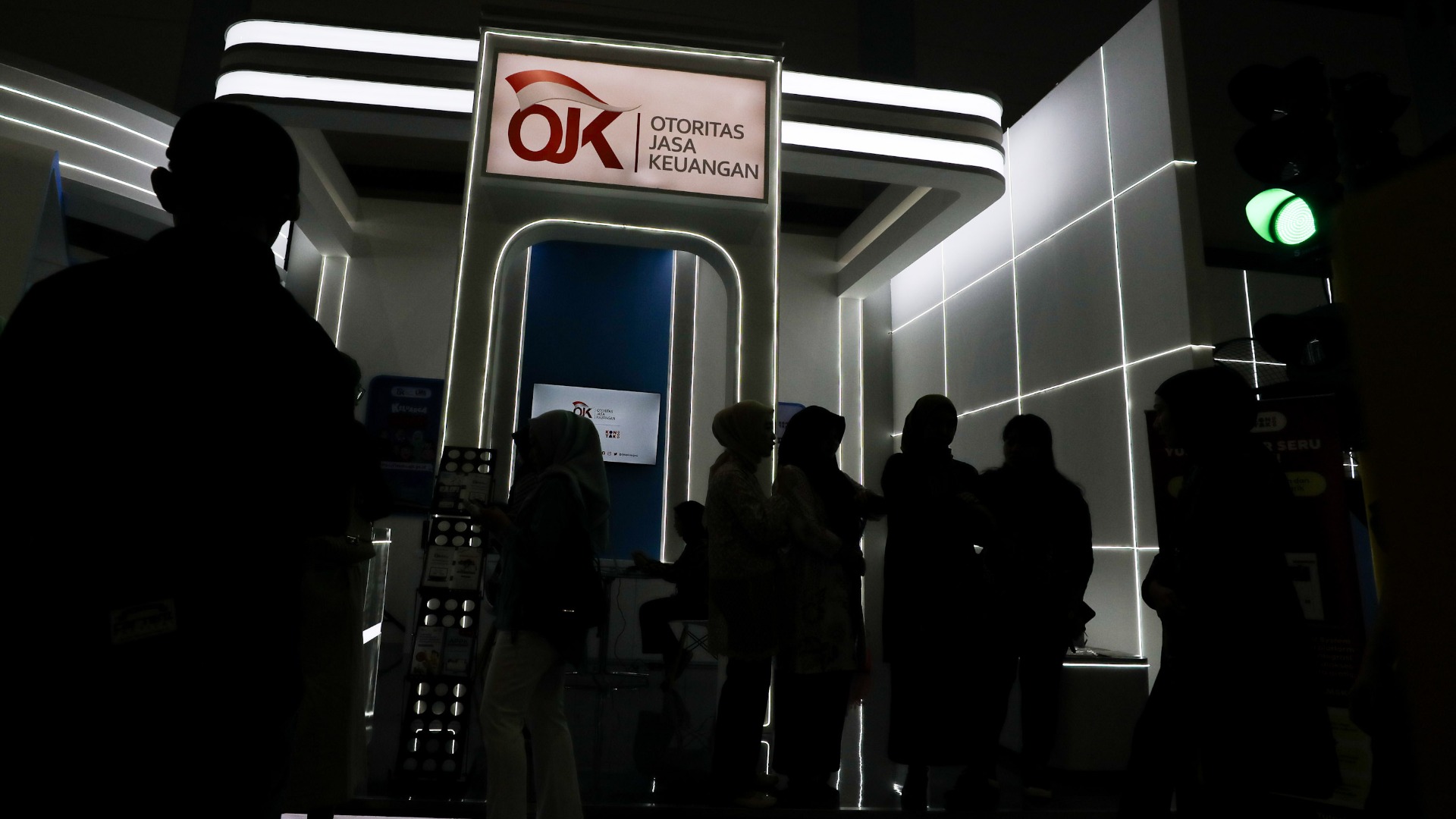 Siluet pengunjung mencari informasi literasi keuangan di stan OJK saat Festival Ekonomi Keuangan Digital dan Karya Kreatif Indonesia (FEKDI x KKI) 2024 di Jakarta, Jumat (2/8/2024)./Bisnis- Arief Hermawan P