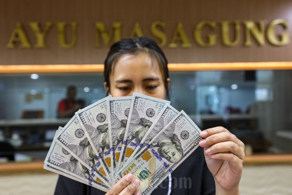 Karyawati menghitung dolar Amerika Serikat di salah satu tempat penukaran uang di Jakarta, Rabu (17/4/2024). Bisnis/Abdurachman