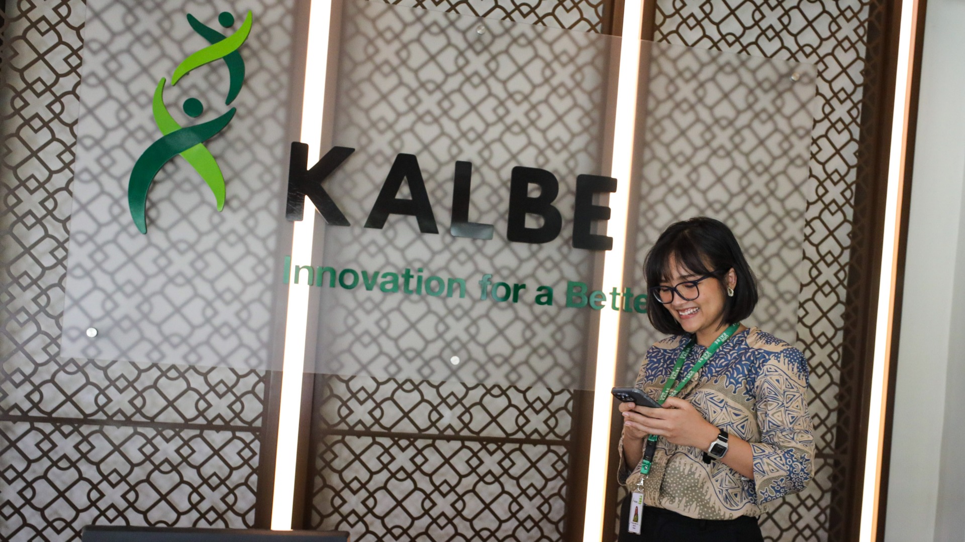 Karyawati beraktivitas di dekat logo Kalbe Farma di Jakarta, Senin (15/7/2024). Bisnis/Arief Hermawan P