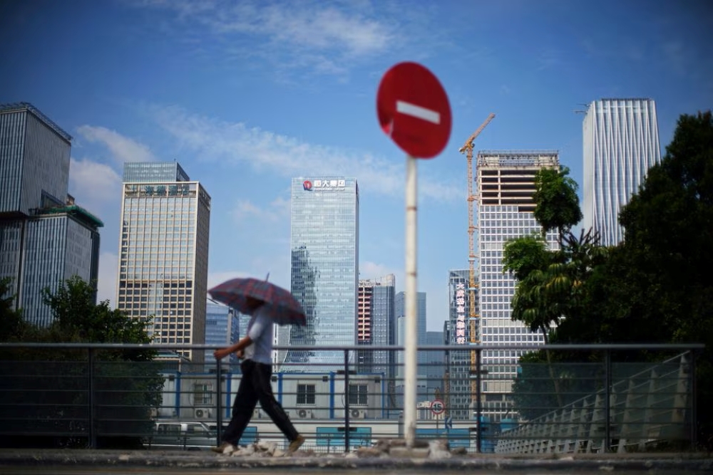 Seorang pria berjalan di Shenzhen, provinsi Guangdong, China 26 September 2021./Reuters