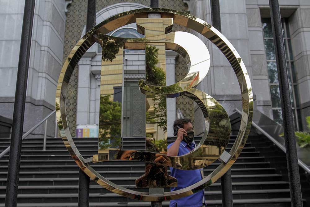 Pekerja melintas dekat logo Bank Indonesia di Jakarta. Bisnis/Fanny Kusumawardhani