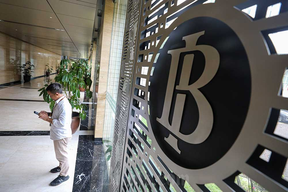 Karyawan berada di dekat logo Bank Indonesia di Jakarta. Bisnis/Arief Hermawan P