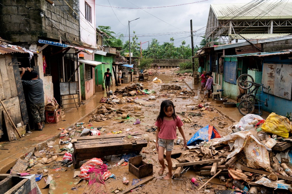 Seorang gadis kecil berjalan melalui puing-puing dan lumpur akibat banjir yang dibawa oleh Topan Gaemi di Marikina City, Metro Manila, Filipina, Kamis (25/7/2024)./Reuters-Lisa Marie David