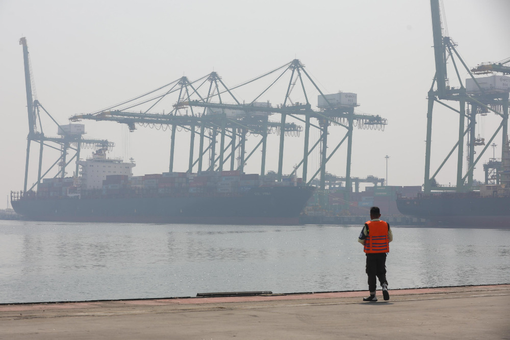 Petugas di sekitar lokasi bongkar muat kontainer dari kapal di pelabuhan New Priok Container Terminal One (NPCT1), Tanjung Priok, Jakarta. / Bisnis-Himawan L Nugraha