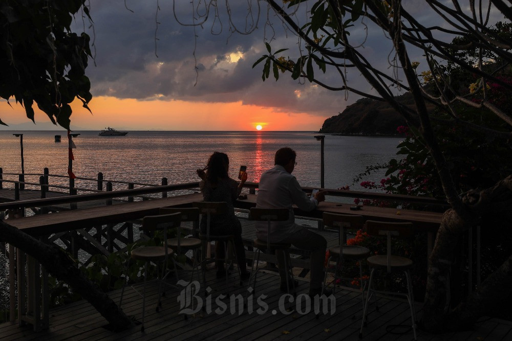 WISATAWAN KE LABUAN BAJO Wisatawan menikmati matahari tenggelam di Pantai Waecicu, Manggarai Barat, Nusa Tenggara Timur (NTT), Minggu (20/8/2023)./Bisnis-Himawan L Nugraha