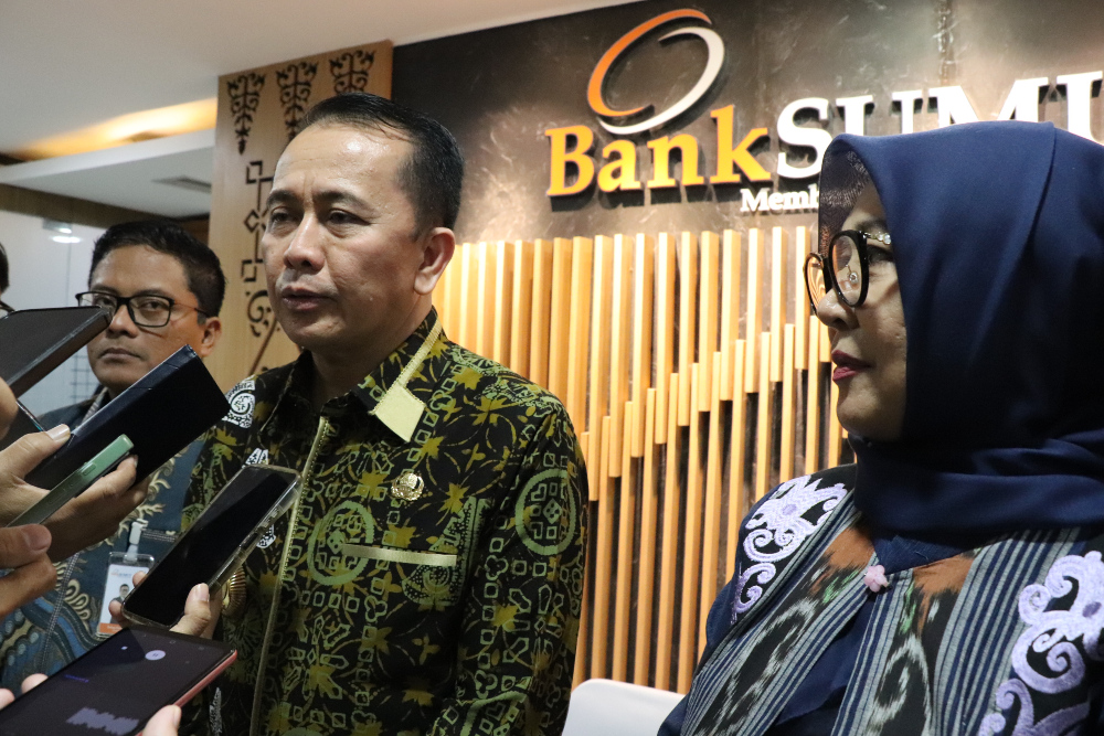 Penjabat Gubernur Sumatra Utara A Fatoni (tengah) didampingi Direktur Utama PT Bank Sumut Babay Parid Wazdi (kiri) dan Komisaris Independen PT Bank Sumut Erlina (kanan) menjawab pertanyaan awak media usai rapat umum pemegang saham luar biasa (RUPS LB) PT Bank Sumut di Kantor Pusat Bank Sumut, Medan pada Jumat (29/11/2024). / Bisnis-Delfi Rismayeti