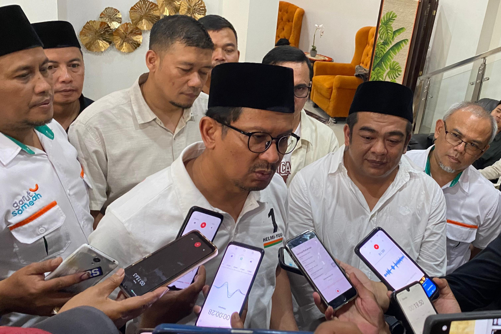 Pasangan Calon Bupati dan Wakil Bupati Garut Helmi Budiman (tengah) dan Yudi Nugraha Lasminingrat (kanan) saat diwawancarai awak media di Garut, Jawa Barat pada Jumat (29/11/2024). / Bisnis-Hakim Baihaqi