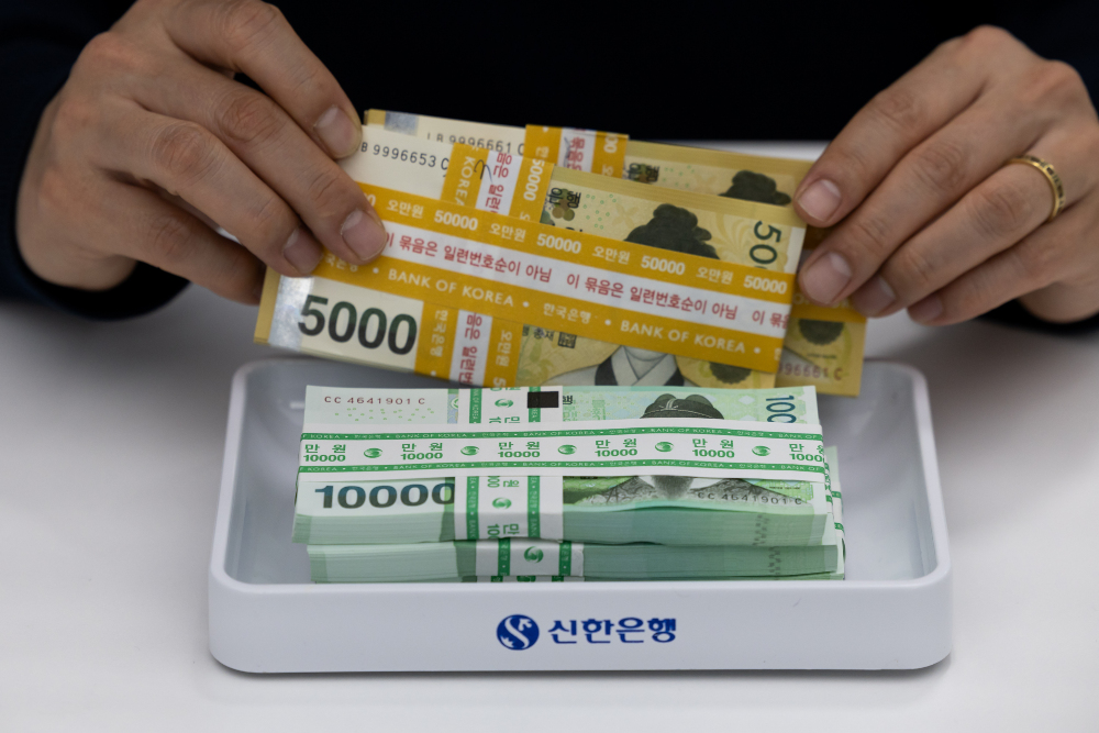 Uang won pecahan 50.000 dan 100.000 dipotret di Seoul, Korea Selatan pada Kamis (18/4/2024). / Bloomberg-SeongJoon Cho