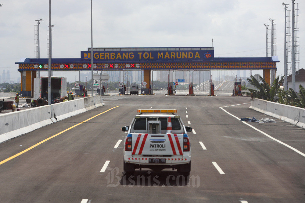 Mobil patroli melintas di proyek Jalan Tol Cibitung - Cilincing (JTCC) Seksi 4 di Jakarta, Rabu (22/2/2023). Bisnis/Suselo Jati