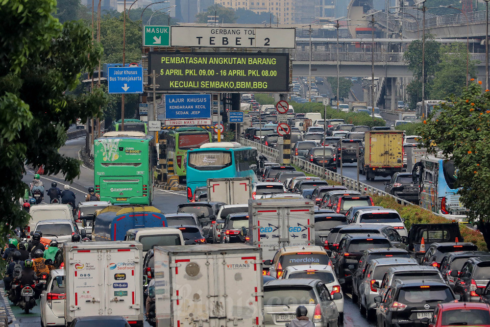 Sejumlah kendaraan melintasi papan elektronik yang menampilkan sosialiasi pembatasan angkutan barang di Gerbang Tol Tebet 2, Jakarta. Bisnis/Eusebio Chrysnamurti