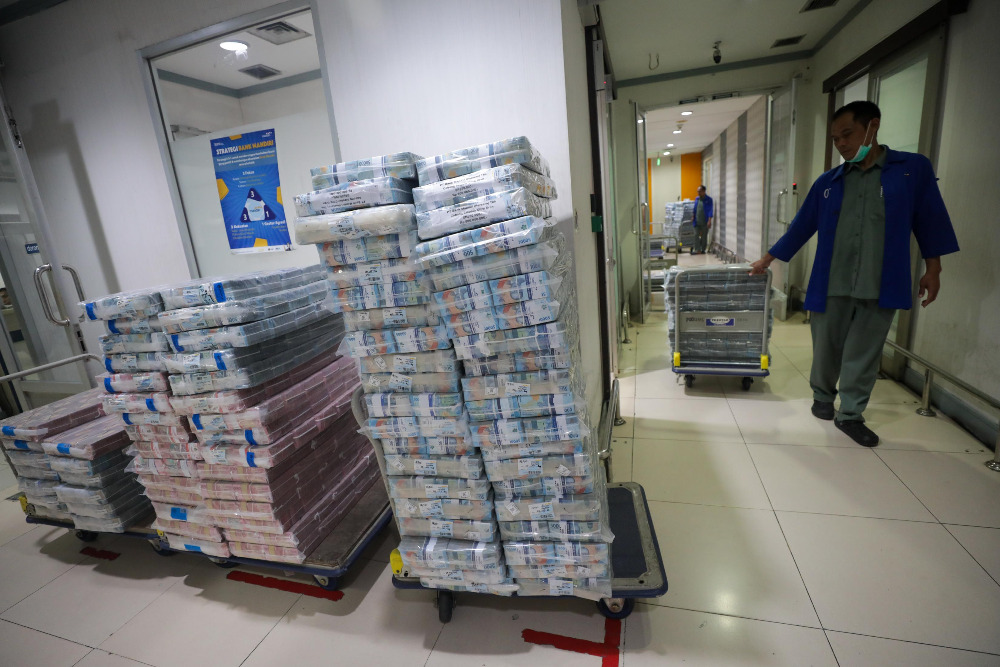 Pegawai merapikan uang rupiah di cash center Bank Mandiri di Jakarta.