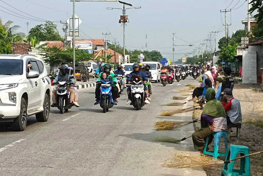 Penyapu koin di Jembatan Sewo, perbatasan Subang dan Indramayu, Jawa Barat pada Senin (8/4/2024). Para penyapu koin memadati jalur tersebut setiap masa arus mudik atau jelang lebaran. - Bisnis/Rizqi Rajendra