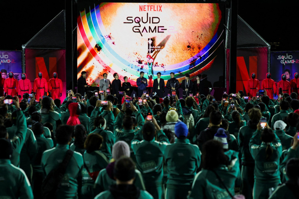 Para pemeran berada di panggung saat acara peluncuran serial Squid Game: Season 2 di Los Angeles, California, Amerika Serikat pada Kamis (12/12/2024). / Reuters-Daniel Cole