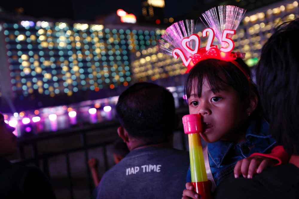 Seorang gadis mengenakan ikat kepala '2025' saat menghadiri perayaan Malam Tahun Baru di Jakarta, Indonesia, 31 Desember 2024/REUTERS-Willy Kurniawan