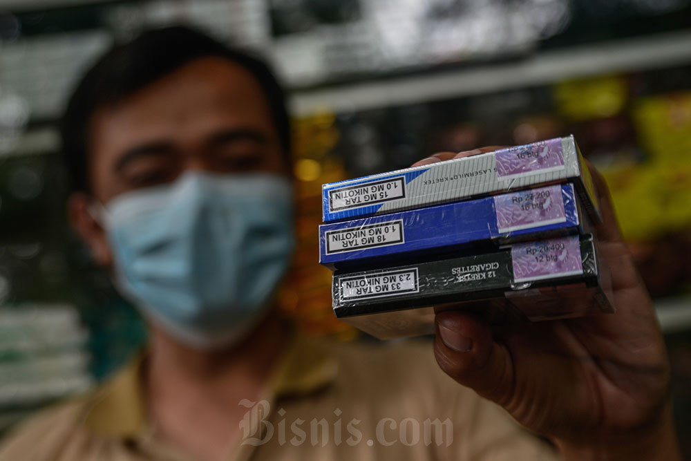 Pedagang memegang bungkus rokok bercukai di Jakarta. Bisnis/Eusebio Chrysnamurti