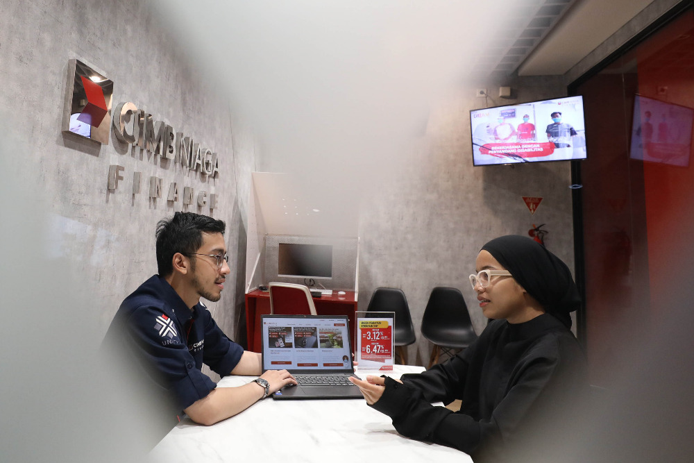 Karyawan melayani nasabah di kantor PT CIMB Niaga Auto Finance atau CIMB Niaga Finance (CNAF), Tangerang Selatan, Banten, Senin (15/7/2024). / Bisnis-Eusebio Chrysnamurti