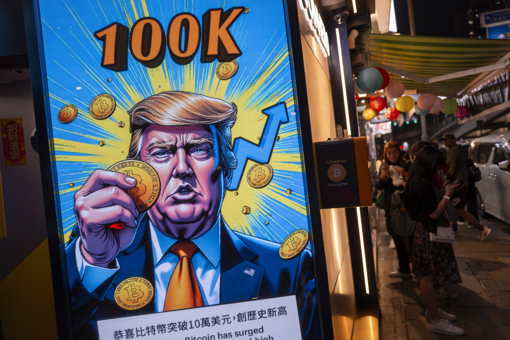 Gambar Presiden Terpilih AS Donald Trump memegang token Bitcoin di Hong Kong pada Kamis (5/12/2024), menandai harga aset kripto itu yang menyentuh US$100.000. / Bloomberg-Justin Chin