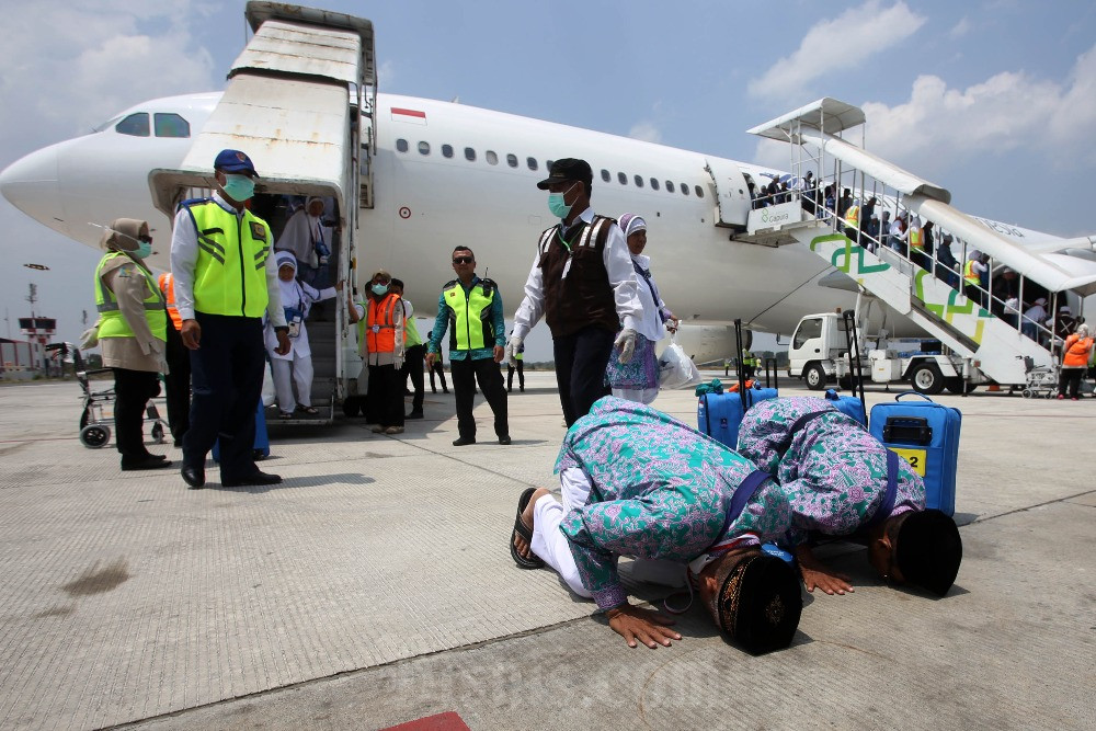 Jemaah haji melakukan sujud syukur saat tiba di Bandara Adi Soemarmo, Ngemplak, Boyolali, Jawa Tengah. Bisnis