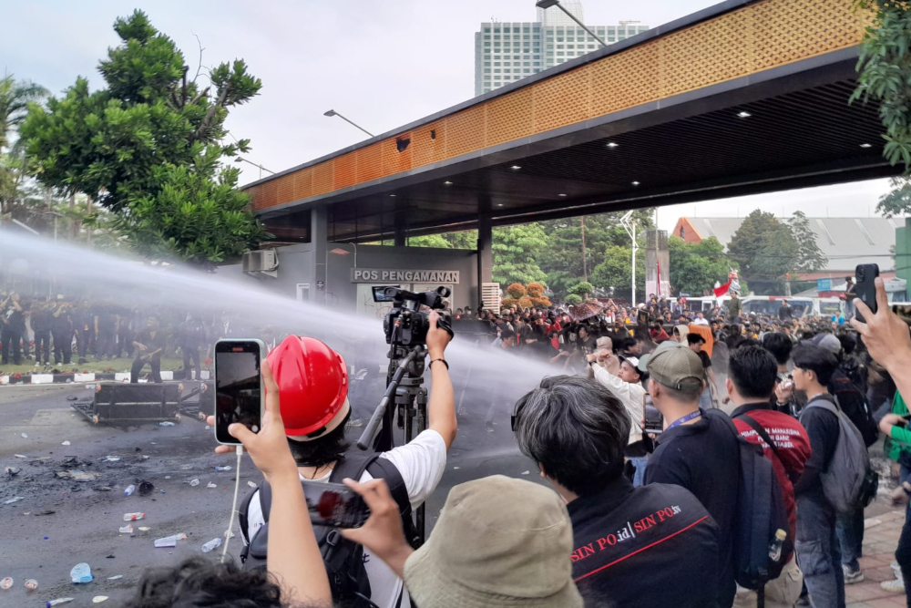 Polisi menembakkan air ke arah massa aksi demo penolakan RUU Pilkada di Gerbang Pancasila Gedung DPR, Jakarta pada Kamis (22/8/2024). / Bisnis-Dany Saputra