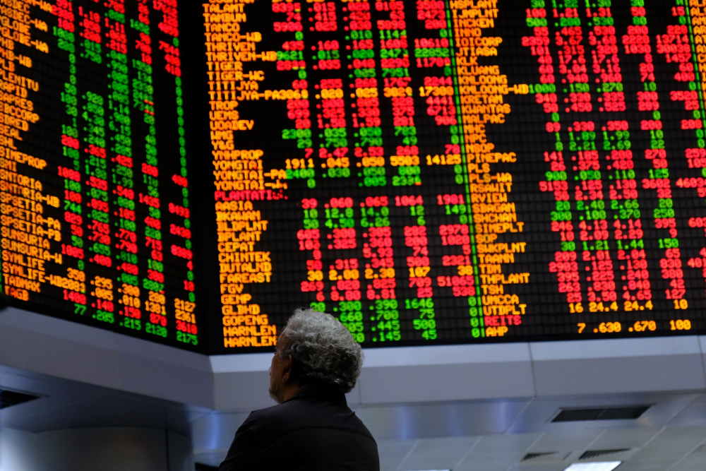 Investor mengamati papan informasi saham di kantor pusat RHB Investment Bank Bhd., Kuala Lumpur, Malaysia pada Selasa (17/2/2020). / Bloomberg-Samsul Said