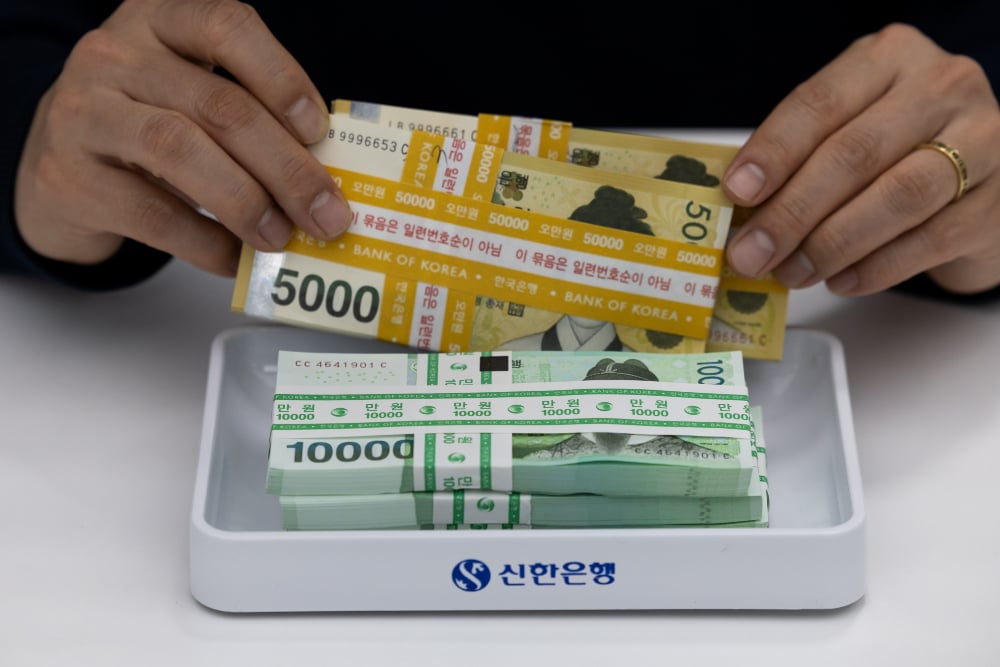 Ilustrasi uang won pecahan 50.000 dan 100.000 dipotret di Seoul, Korea Selatan pada Kamis (18/4/2024). / Bloomberg-SeongJoon Cho