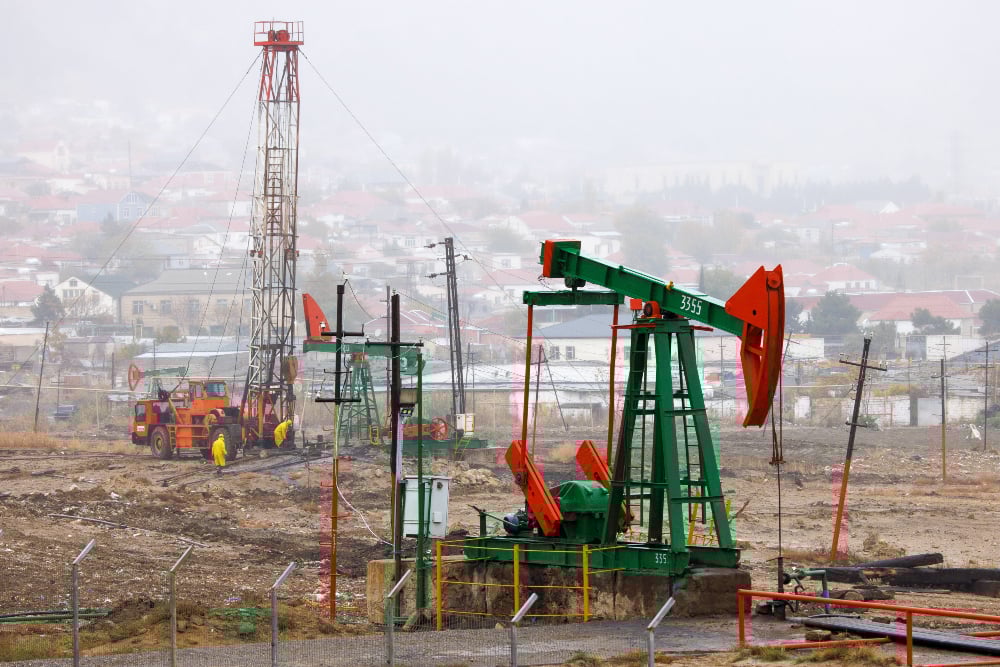 Pompa angguk atau pump unit dan drilling rigs beroperasi di kilang minyak dekat Laut Kaspia, Baku, Azerbaijan pada Kamis (14/11/2024). / Bloomberg-Andrey Rudakov