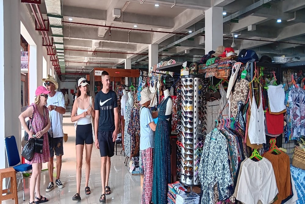 Wisatawan mancanegara sedang berjalan  di Pasar Seni Sukawati. Pasar ini direvitalisasi oleh pemerintah pada 2020 dan 2022 untuk menambah kenyamanan wisatawan saat berbelanja/Bisnis.com- Harian Noris Saputra