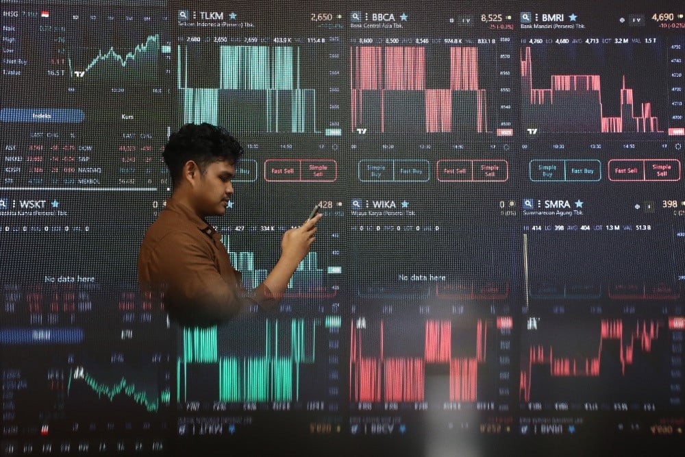 Karyawan beraktivitas didepan layar yang menampilkan pergerakan harga saham di Jakarta, Rabu (16/7/2025)./JIBI/Bisnis/Eusebio Chrysnamurti
