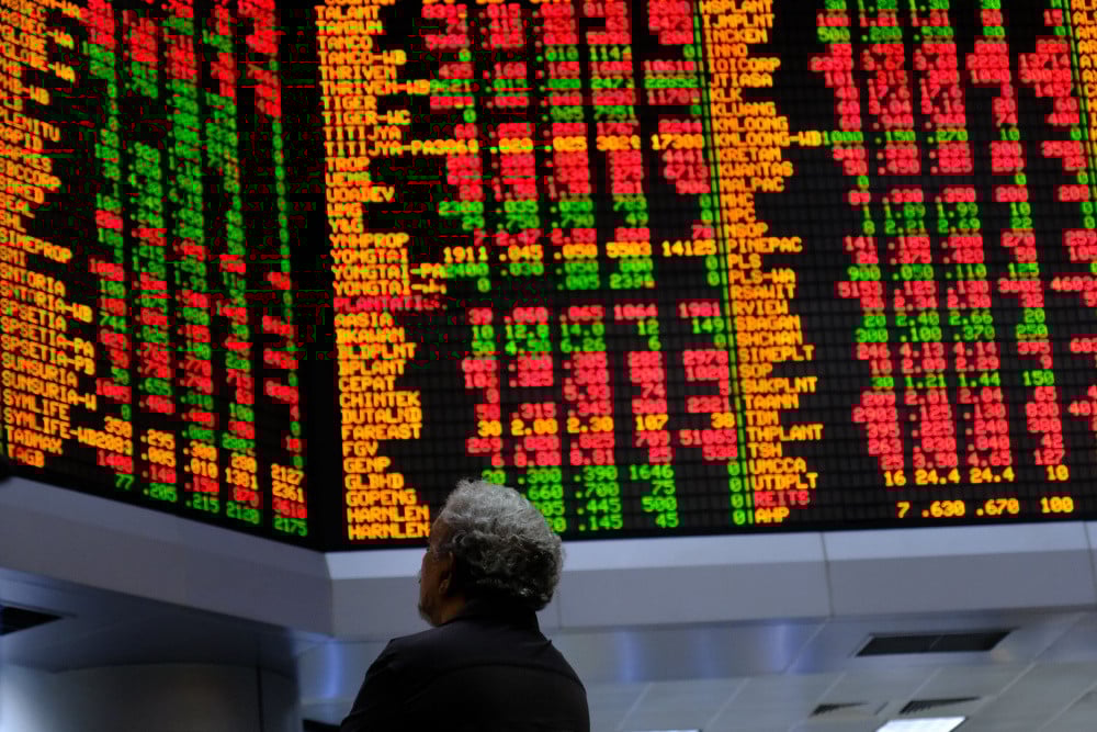Investor mengamati papan informasi saham di kantor pusat RHB Investment Bank Bhd., Kuala Lumpur, Malaysia pada Selasa (17/2/2020). / Bloomberg-Samsul Said