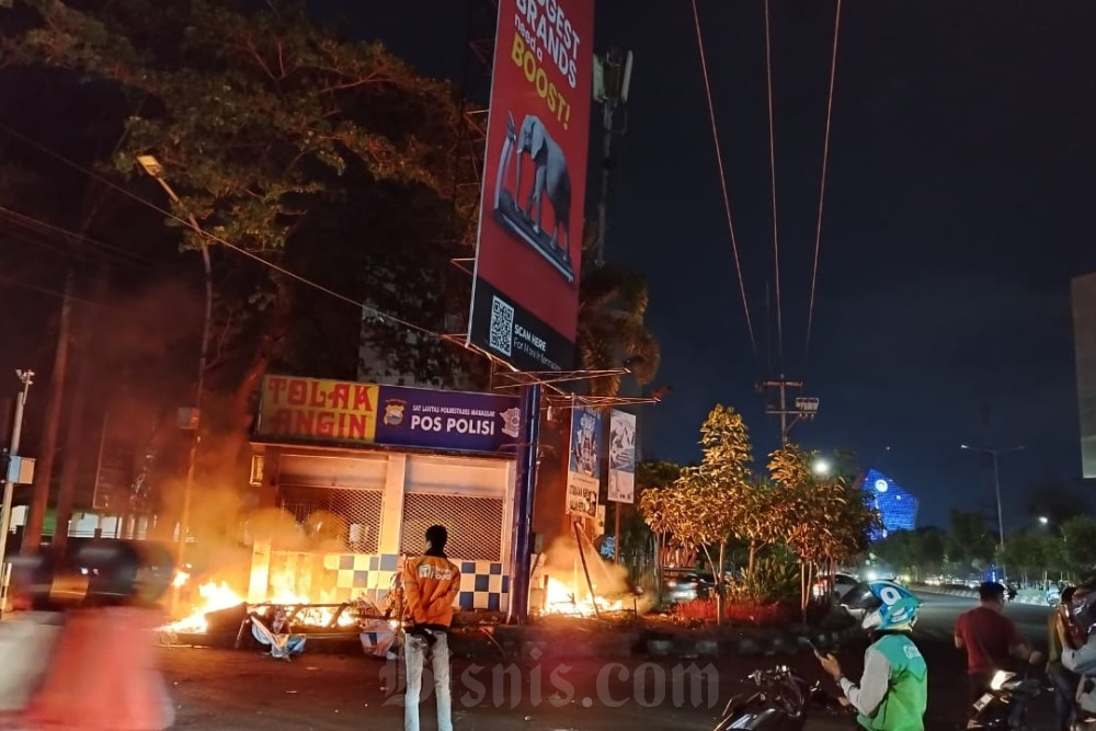 Pos polisi di dirusak demonstran di Makassar./Bisnis-Paulus Tandi Bone