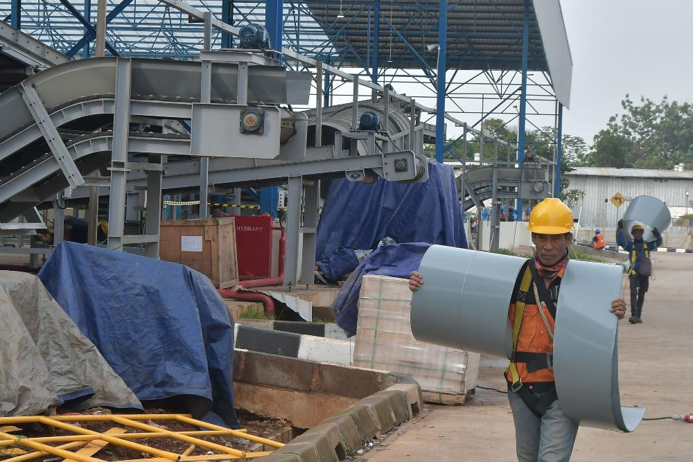Sejumlah pekerja menyelesaikan proses pemasangan mesin untuk pengolahan sampah Landfill Mining dan RDF (Refuse Derived Fuel) Plant di TPST (Tempat Pembuangan Sampah Terpadu) Bantargebang, Bekasi, Jawa Barat, Senin (2/1/2023). Landfill Mining dan RDF Plant dapat mengolah sampah 2000 ton per hari yang saat ini telah mencapai tahap uji coba dan progres pembangunannya telah mencapai 98 persen. ANTARA FOTO/Fakhri Hermansyah/wsj.